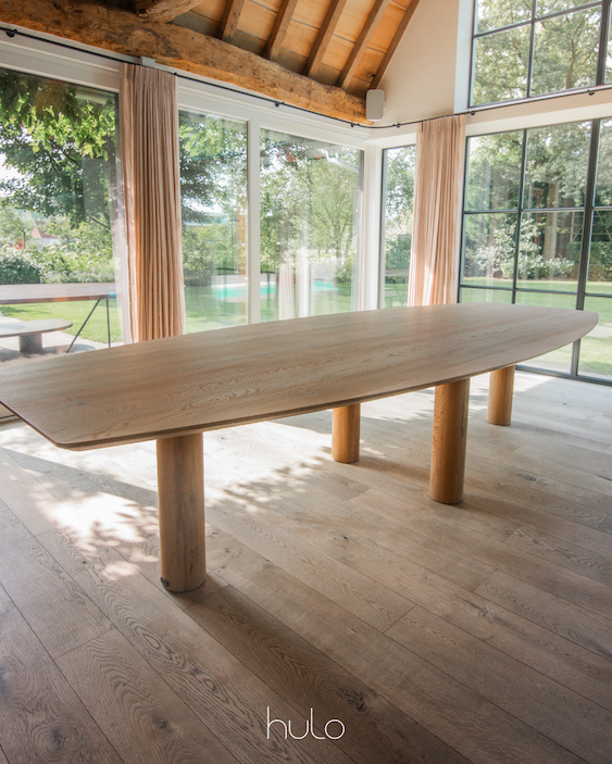 Tafel massief eik met groot tafelblad. Grote houten cilinervormige tafelpoten.