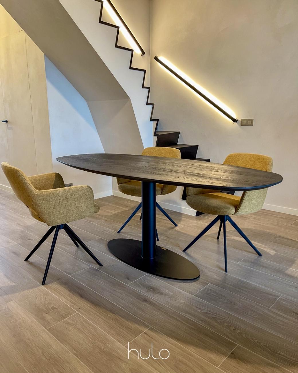 Massief eikenhouten tafel met een metalen onderstel. Gecombineerd met eetkamerstoelen met een metalen draaionderstel. Bovenkant gestoffeerd