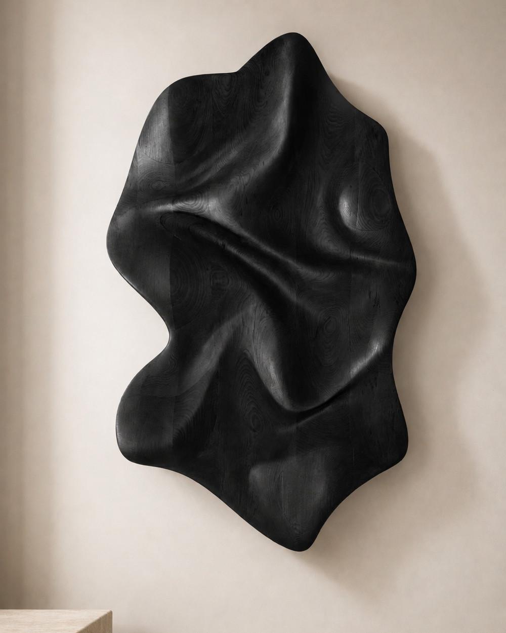 Rheon by NEXART — A sculptural wall object with folded, flowing contours and a dark finish