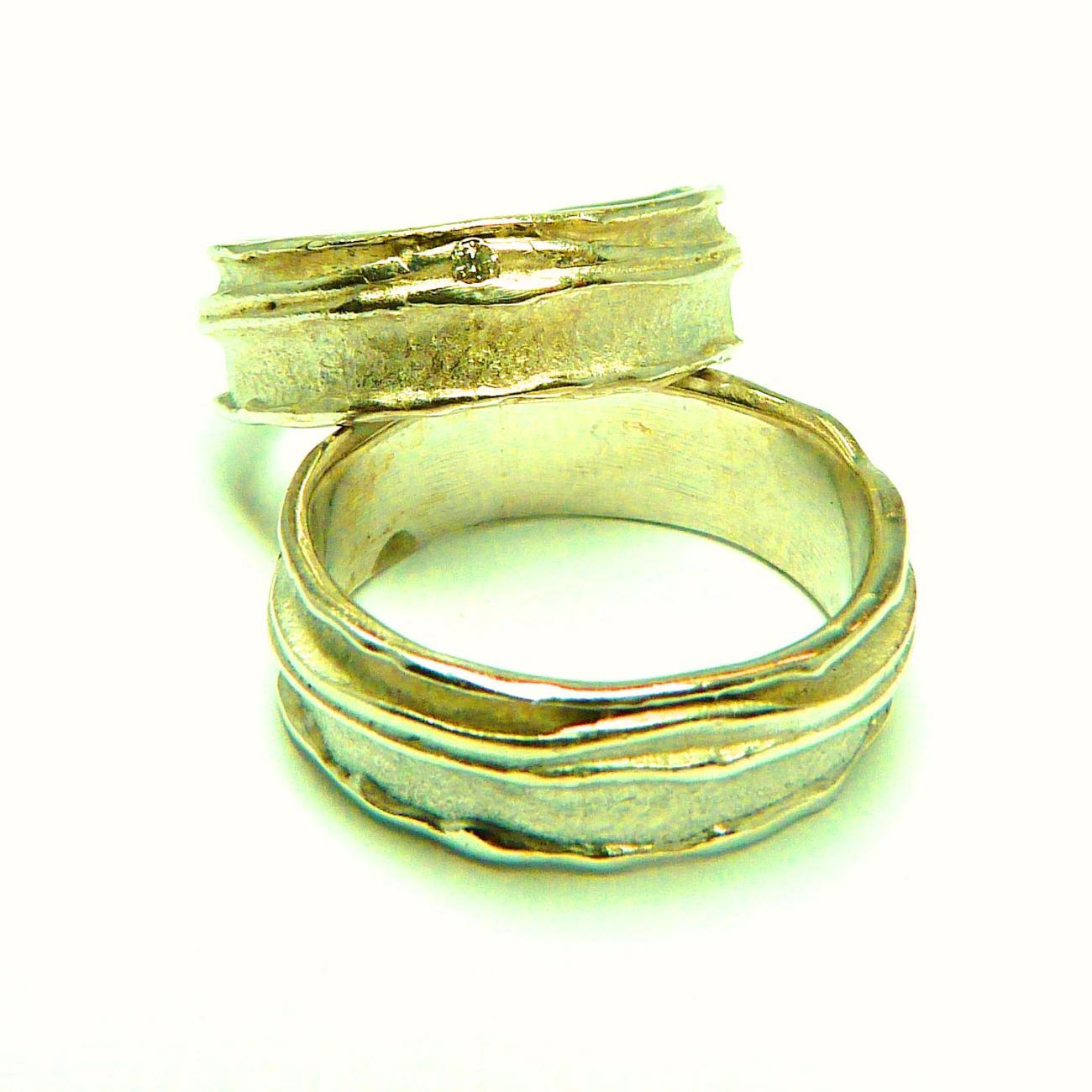 Een aantal lagen metaal op elkaar gesmeed resulteert in deze organische ringen Tussen twee organische randen vind je voor haar een diamantje Geel Goud - Diamant