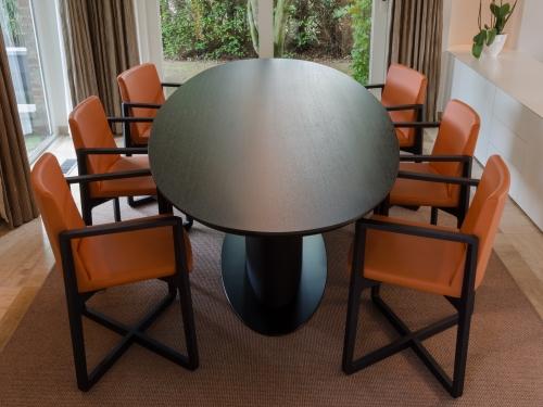 Eik gefineerde tafel, ovale blad, gefineerde ovale voetsteun en zwart gelakt metalen vloerplaat.