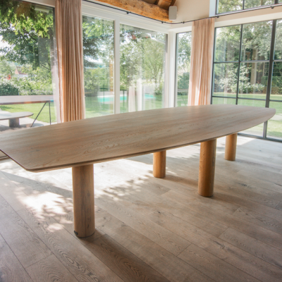 Tafel massief eik met groot tafelblad. Grote houten cilinervormige tafelpoten.
