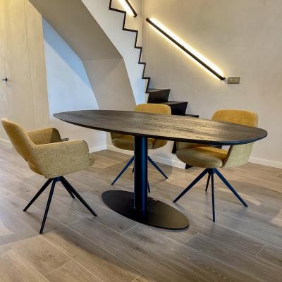 Massief eikenhouten tafel met een metalen onderstel. Gecombineerd met eetkamerstoelen met een metalen draaionderstel. Bovenkant gestoffeerd