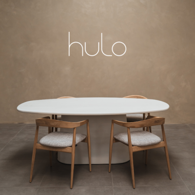 Tafel gemaakt in steenkool. tafelblad heeft de vorm van Deens Ovaal en het onderstel is een piramidevorm. Houten stoelen staan rond de tafel. Tafel is gefotografeerd in fotostudio.
